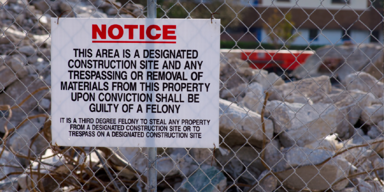 photo of notice sign that says "This area is a designated construction site and any trespassing or removal of materials from this property upon conviction shall be guilty of a felony. It is a third degree felony to steal any property from a designated construction site or to trespass on a designated construction site"